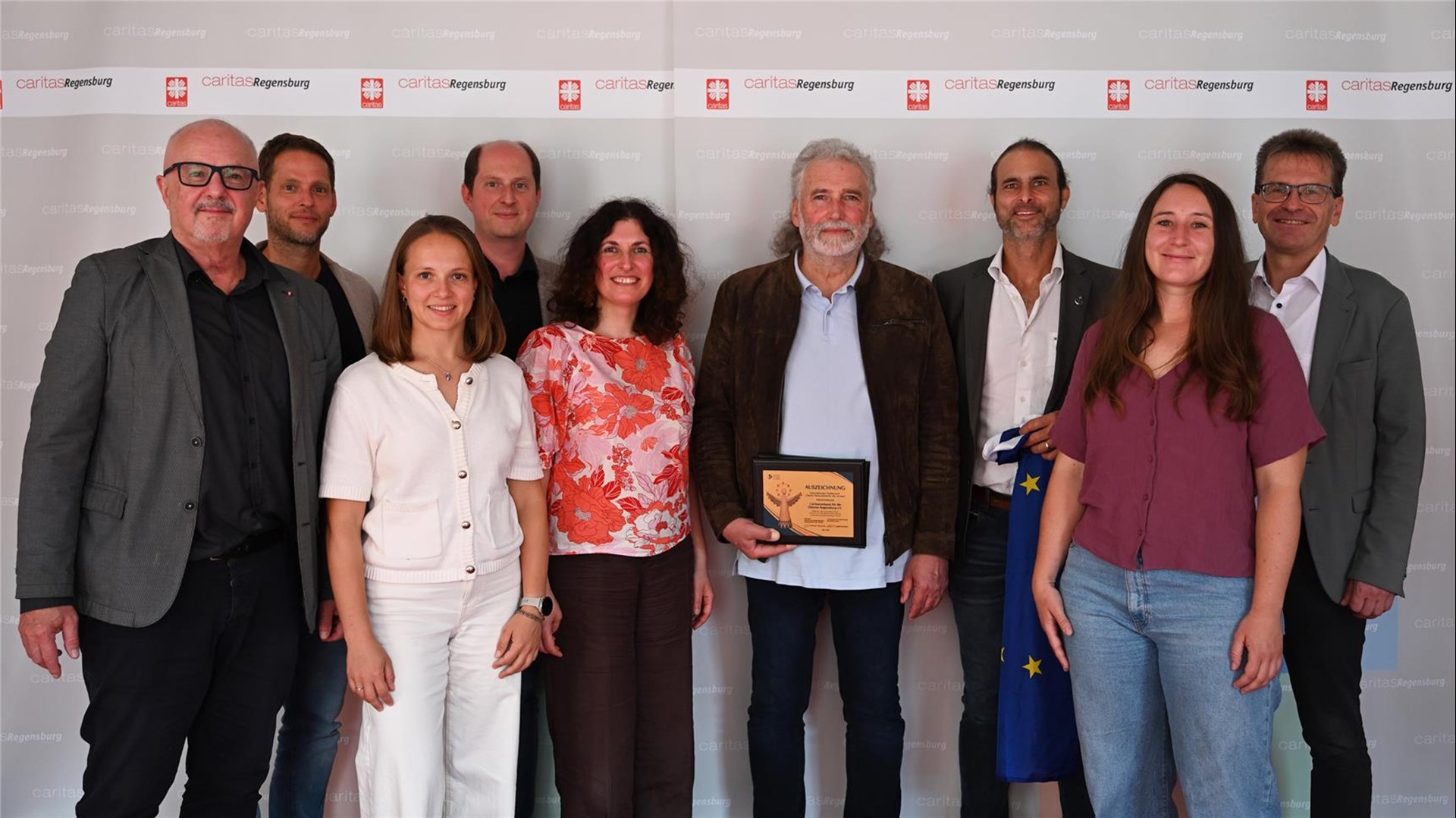 Gruppenfoto mehrerer Menschen, die in die Kamera blicken